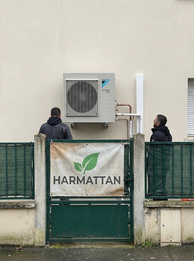 Deux techniciens de dos sous une unité murale, bâche Harmattan sur le portail